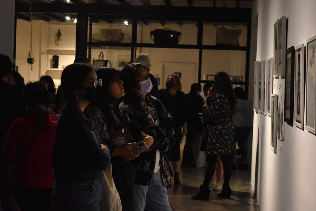 Asistentes observan los grabados durante la inauguración de la exposición. Fotografía: José David López. 